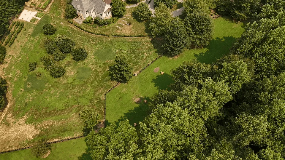 Aerial view of pasture, fencing and woodland edge on a Virginia property